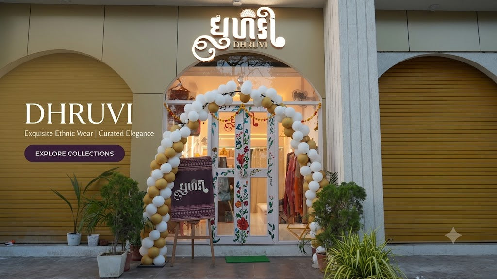 Dhruvi boutique storefront with a decorative white, gold, and beige balloon arch over the entrance, floral door panel, and large signage reading DHRUVI. The scene is set in front of closed mustard-yellow roller shutters with potted plants at the base.